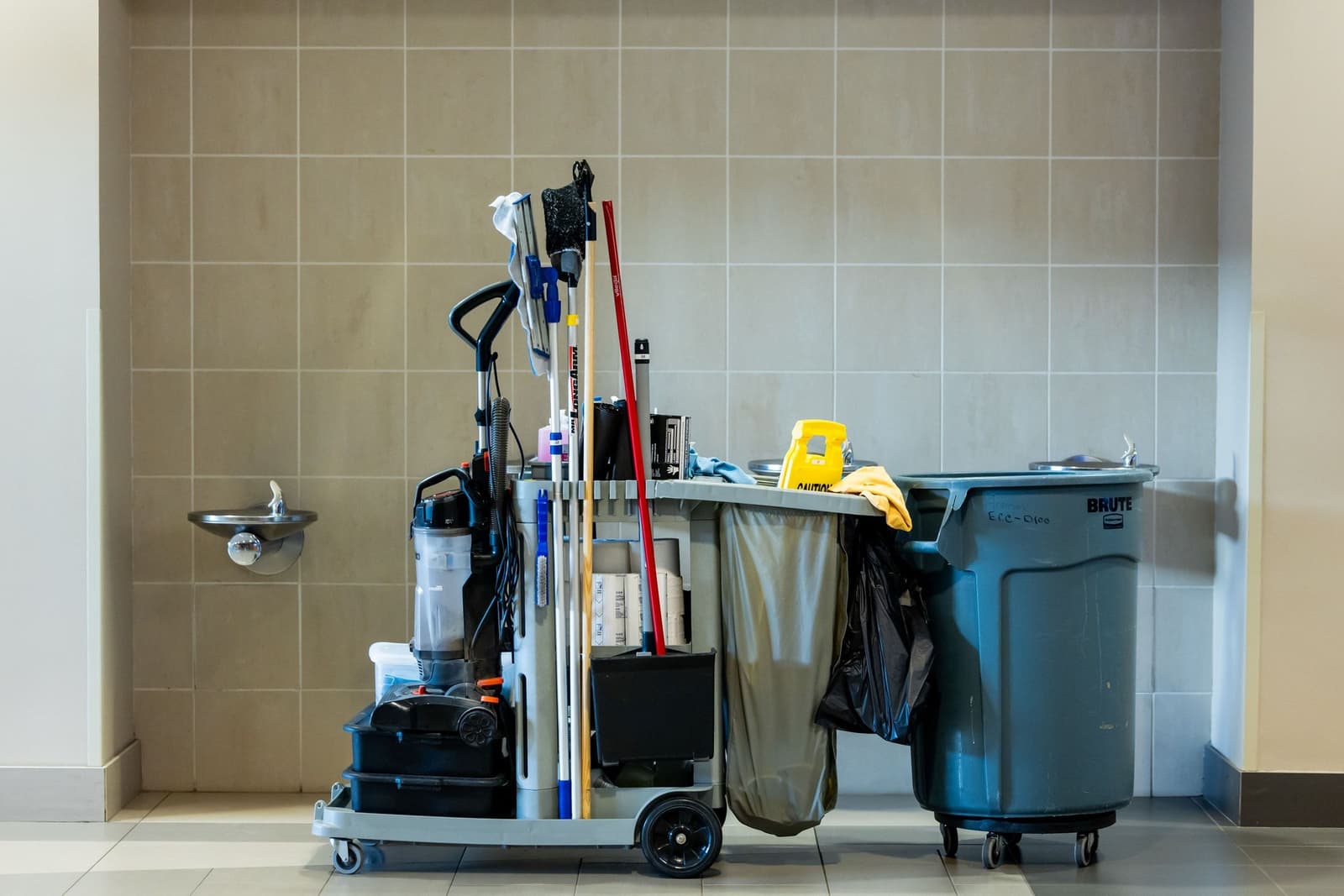 Janitorial cleaning cart staged in a bright commercial building corridor