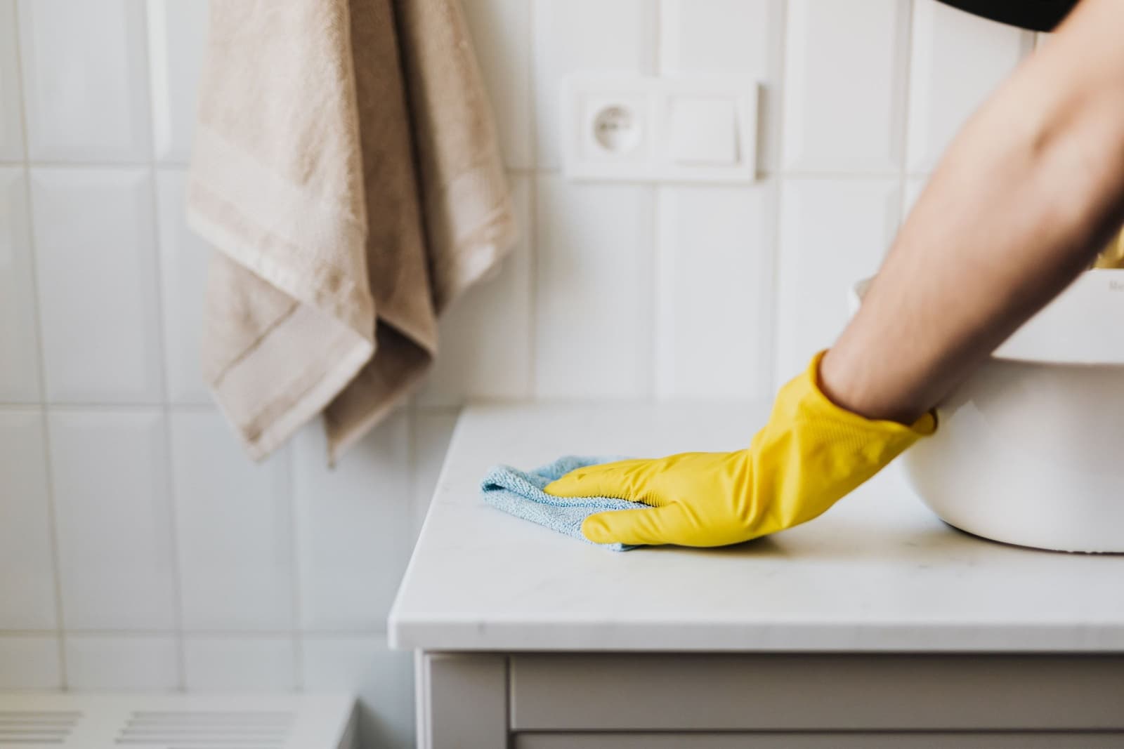 Gloved hand wiping down a clean commercial countertop surface